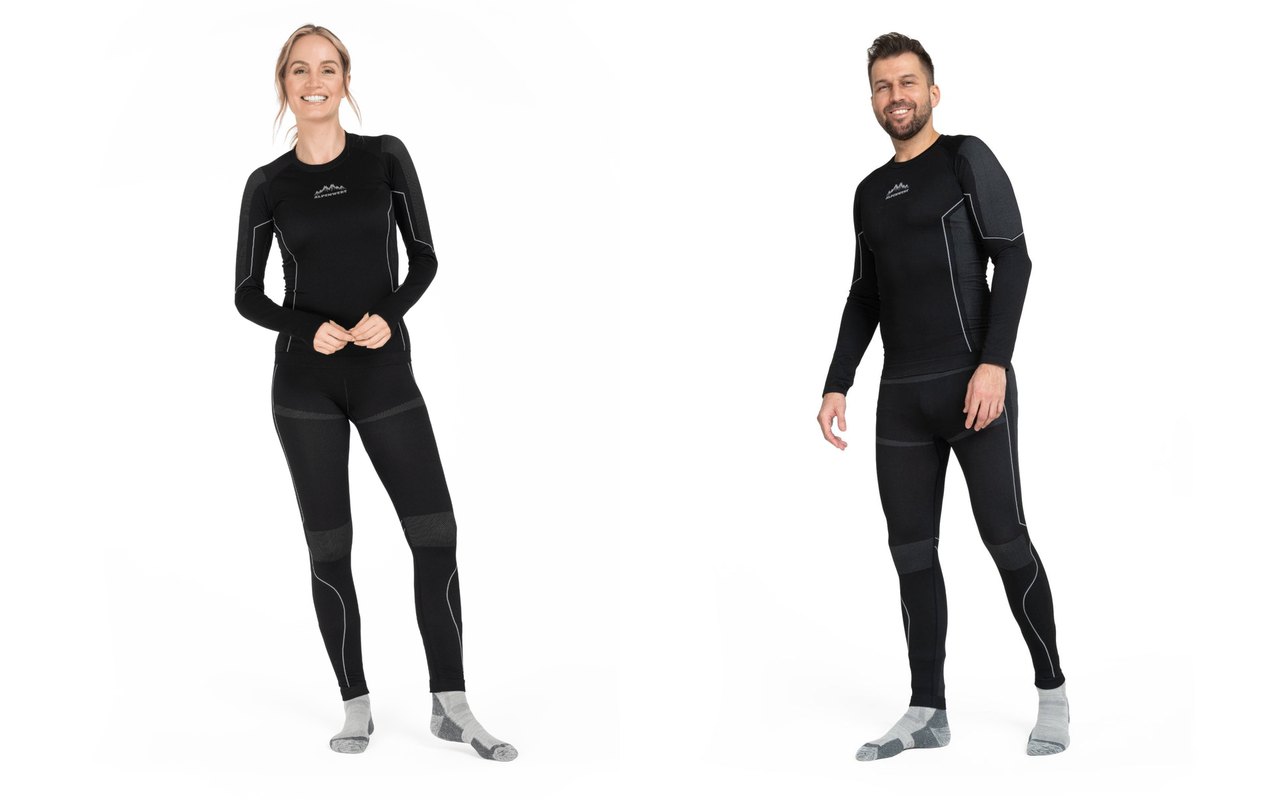 Frau und Mann tragen das schwarze Thermounterwäsche-Set aus langärmligem Oberteil und langer Hose, eng anliegend geschnitten
